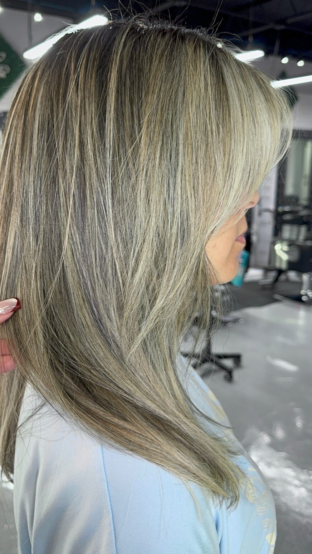 Ash blonde hair with fine highlights and long layers, seen from the side