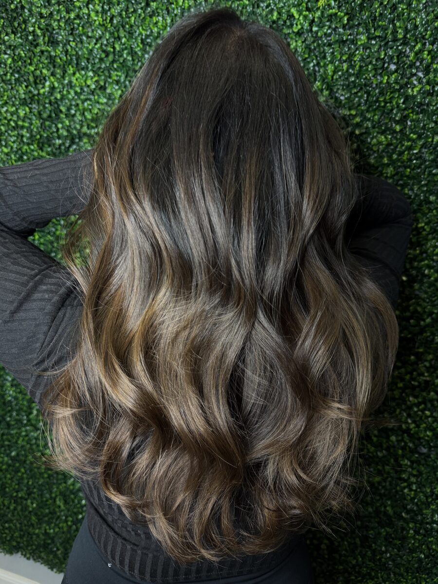 Dark brunette hair with soft balayage and waves, seen from behind