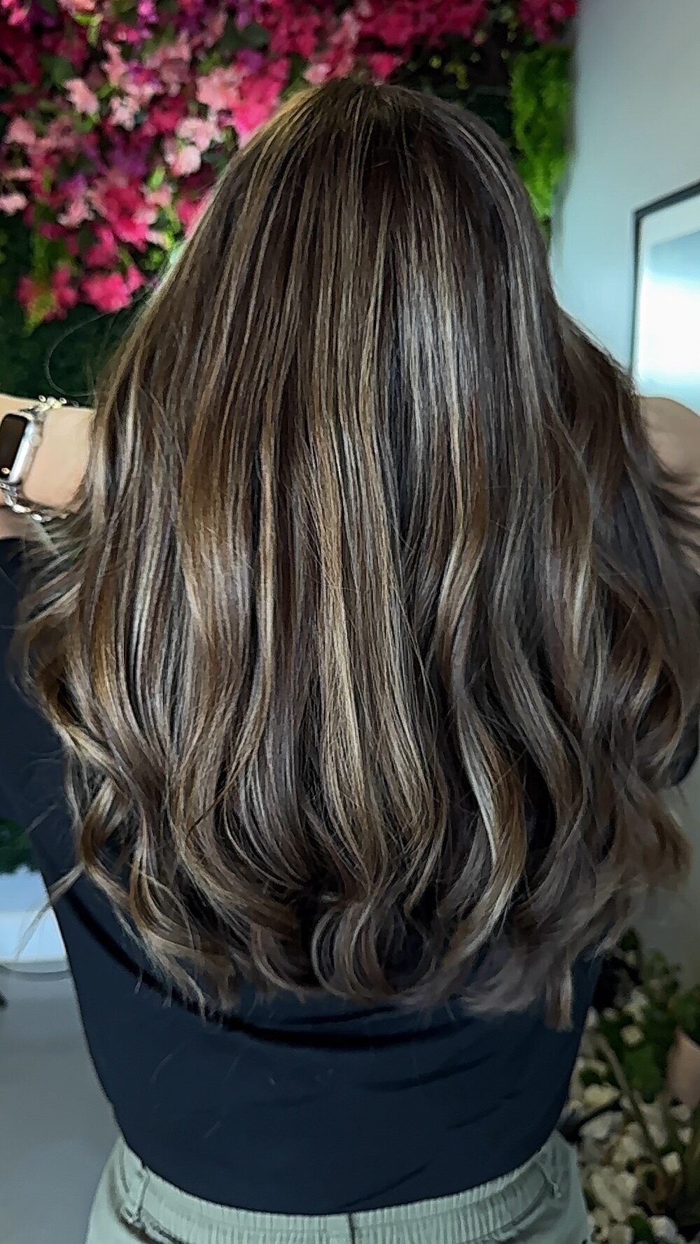 Brunette hair with fine cool highlights and soft curls, seen from behind